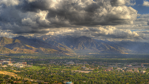 Photo of the University of Utah campus with dramatic strom clouds over the Wasatch Mountains