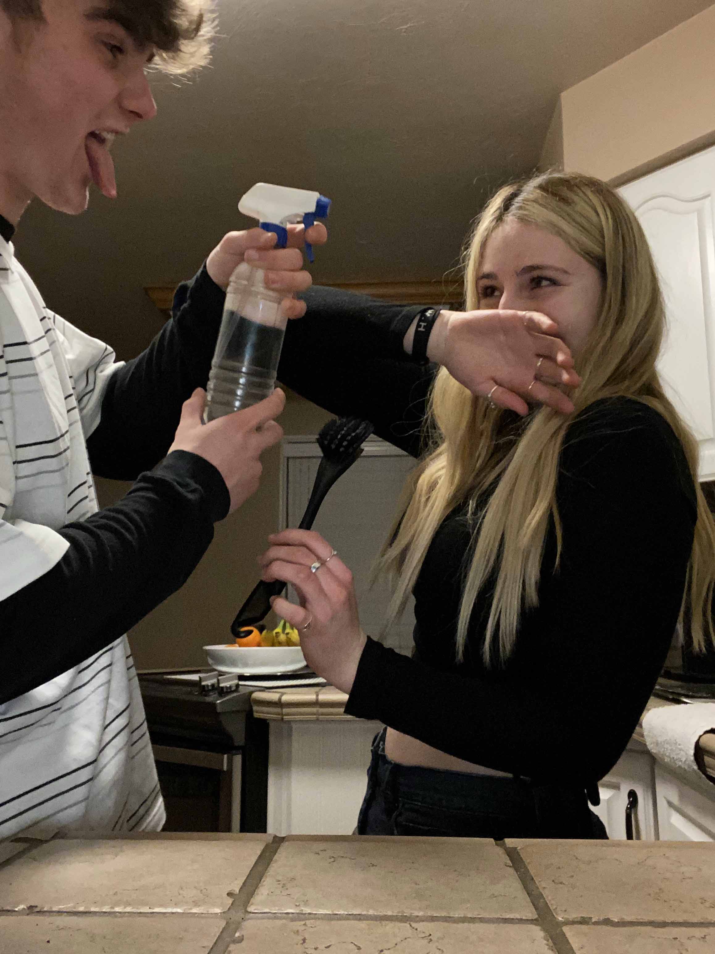 A young man and young woman in a water fight.