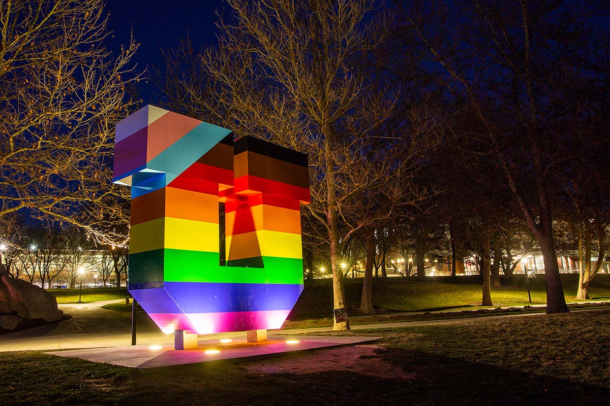 Night photo of the illuminated block U, wrapped in a rainbow of colors