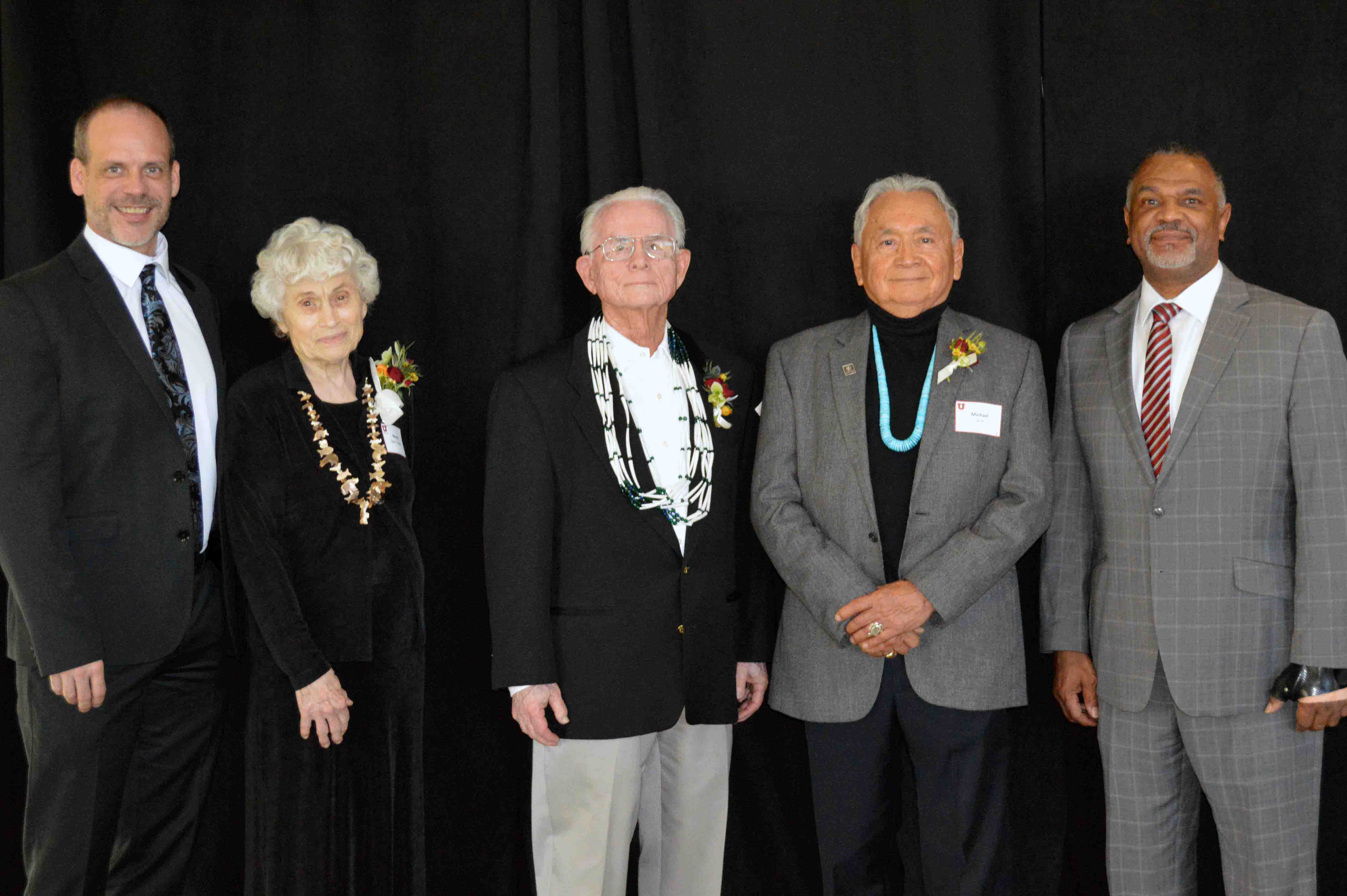 A group of people standing in front of a black backdrop